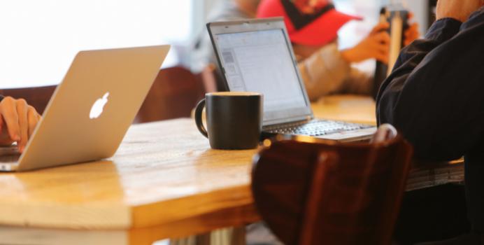 En gruppe mennesker arbejder på bærbare computere på en café