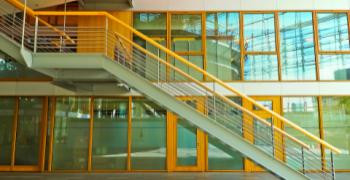 trapper foran glasbygning med gule glasrammer